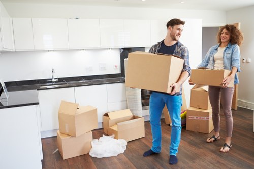 Movers carrying boxed household items in a Tufnell Park flat